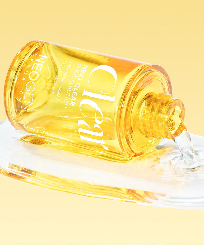 NEOGEN Next Clear Spot Solution 32ml bottle spilling on surface against yellow background