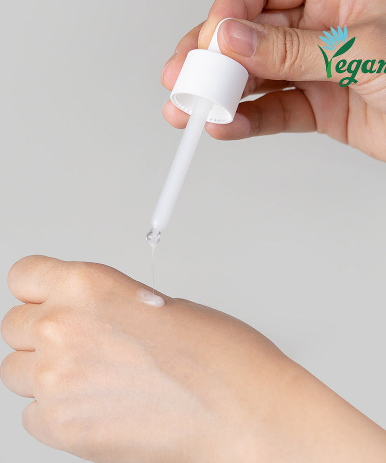Applying NEOGEN Real Niacinamide 15% Serum 30ml with dropper onto hand, vegan skincare product.