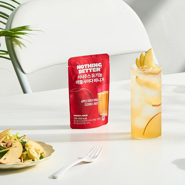 NOTHING BETTER Inner Juice Apple Cider Vinegar Cleanse Juice (X24) next to a glass and salad on a white table