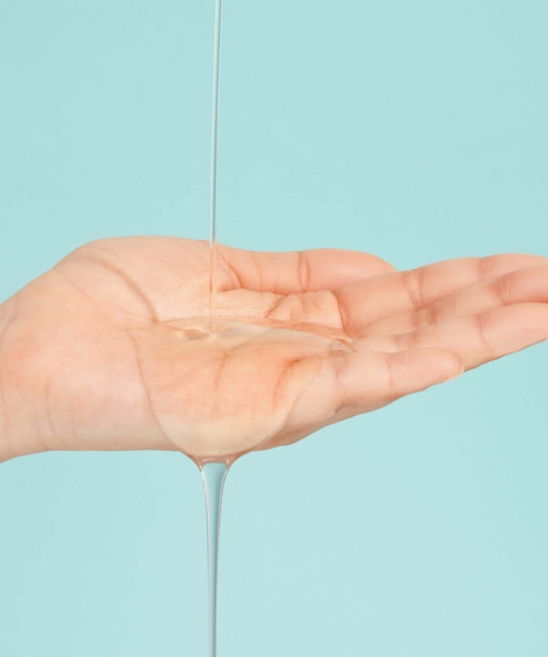 NUMBUZIN No.1 Pantothenic B5 Active Soothing Serum being poured into an open palm against a blue background.
