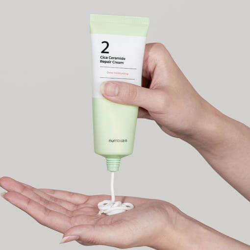 NUMBUZIN No.2 Cica Ceramide Repair Cream being dispensed onto a hand for skincare application.