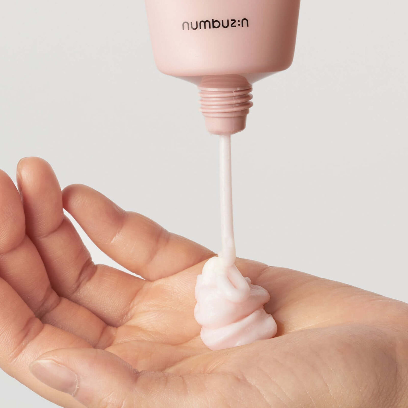 NUMBUZIN No.3 Velvet Beauty Cream being dispensed into a hand, showcasing its smooth texture.