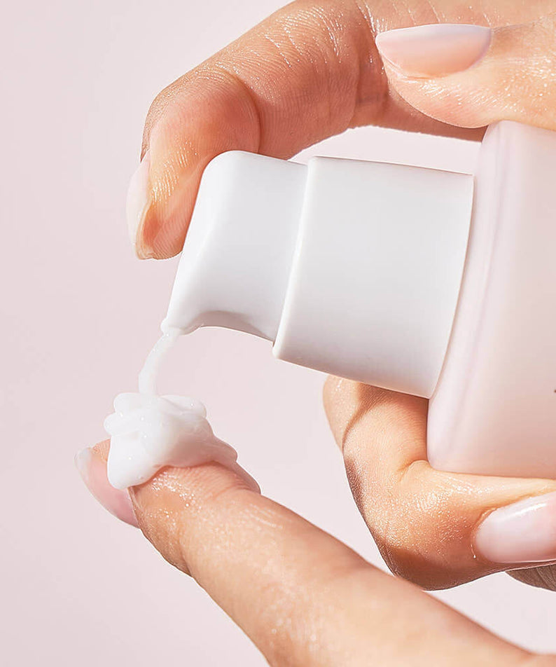 Applying NUMBUZIN No.4 Collagen 73% Pudding Serum to finger with a pump bottle in a skincare routine