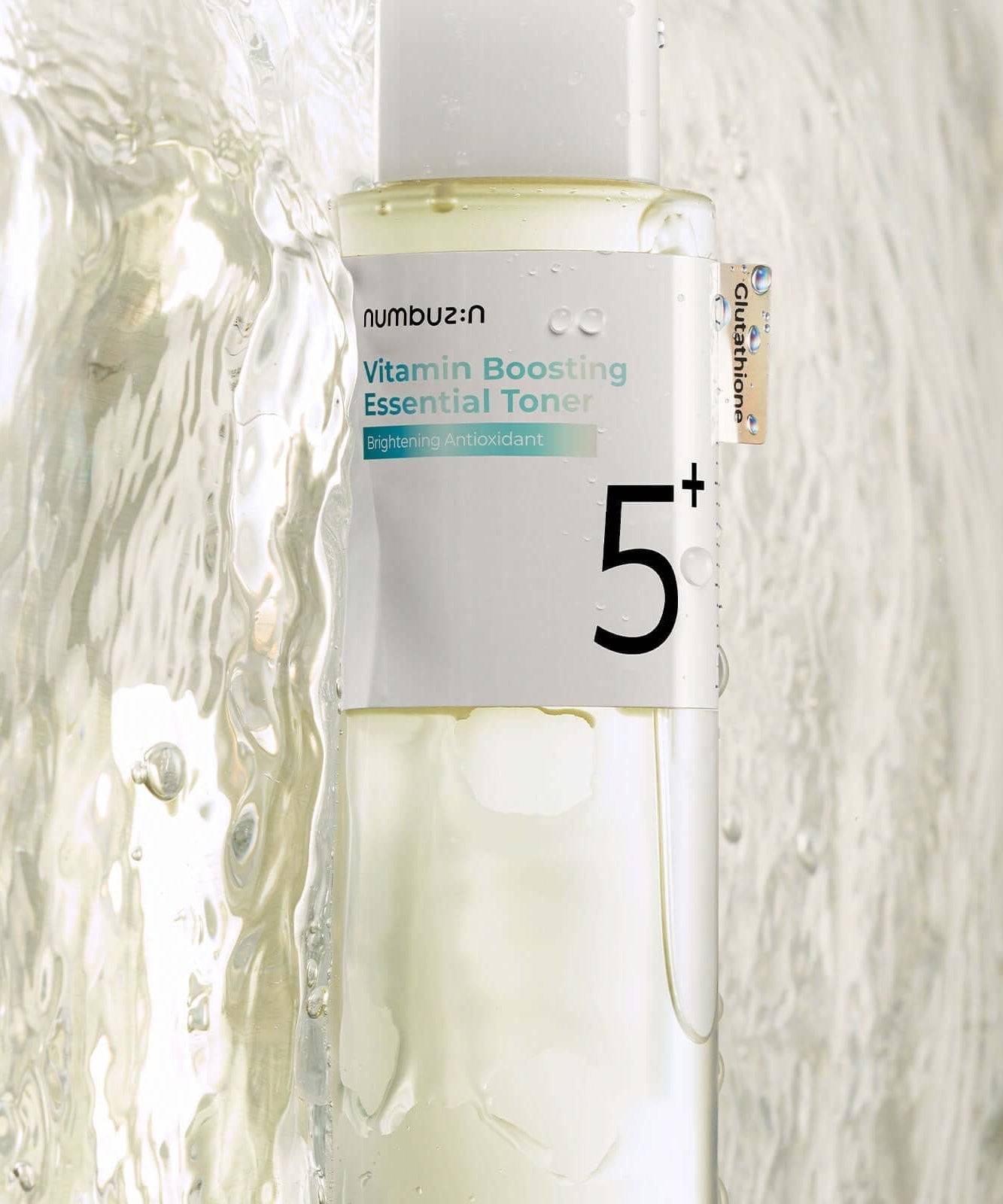 NUMBUZIN No.5 Vitamin Boosting Essential Toner bottle close-up with water splashes, highlighting antioxidant-rich skincare product.