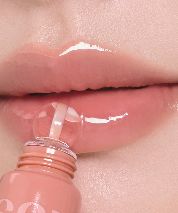 Close-up of lips applying NUSE Nuzzle Reju Lip Gloss, showcasing glossy finish.