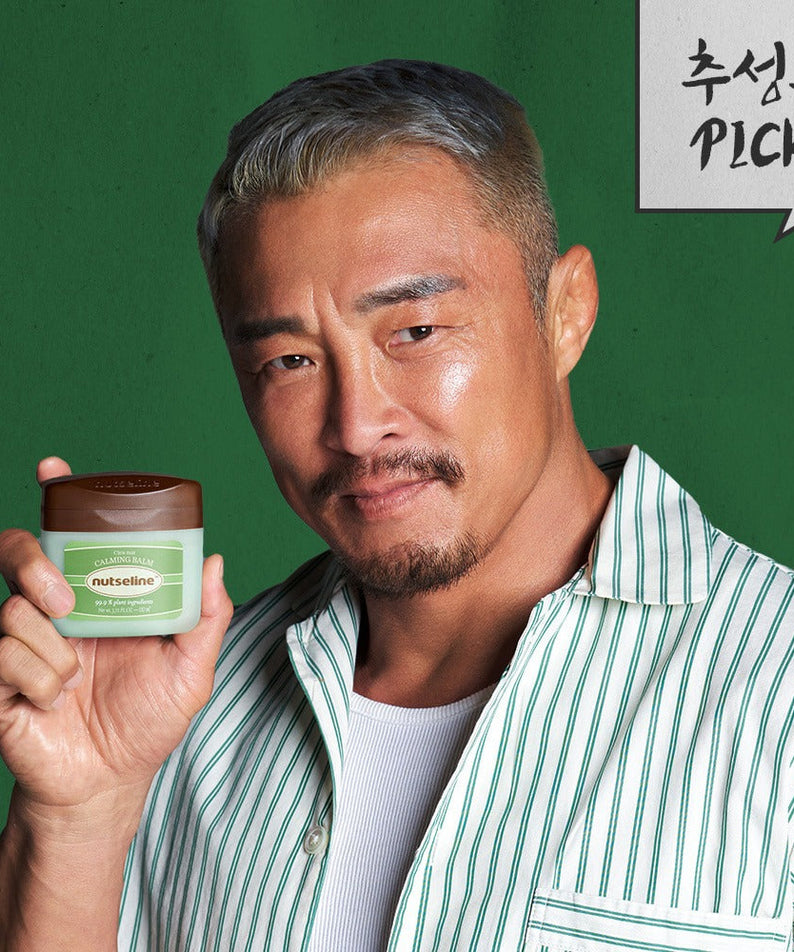 Man holding NUTSELINE Cica Nut Calming Balm Season 2 50ml with green background