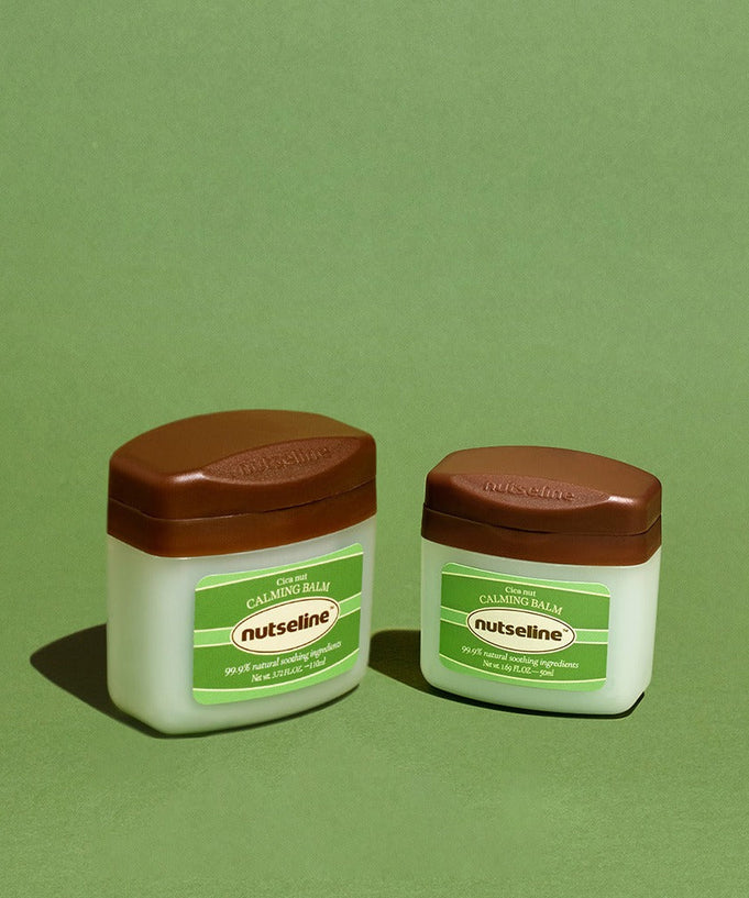 Two jars of NUTSELINE Cica Nut Calming Balm Season 2 50ml on a green background.