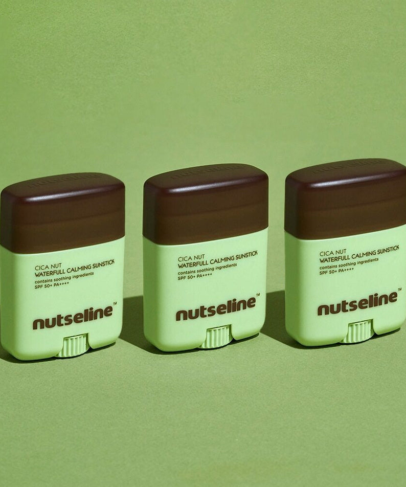 Three NUTSELINE Cica Nut Waterful Calming Sun Stick 20g products on green background