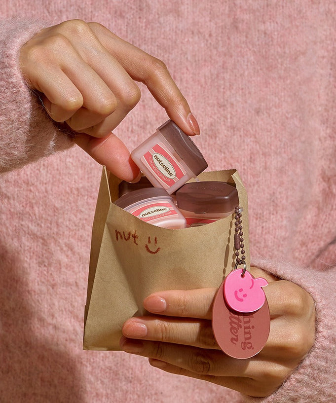 NUTSELINE Super Nut Collagen Keyring Lip Balm 11ml in a paper bag with pink keyring.