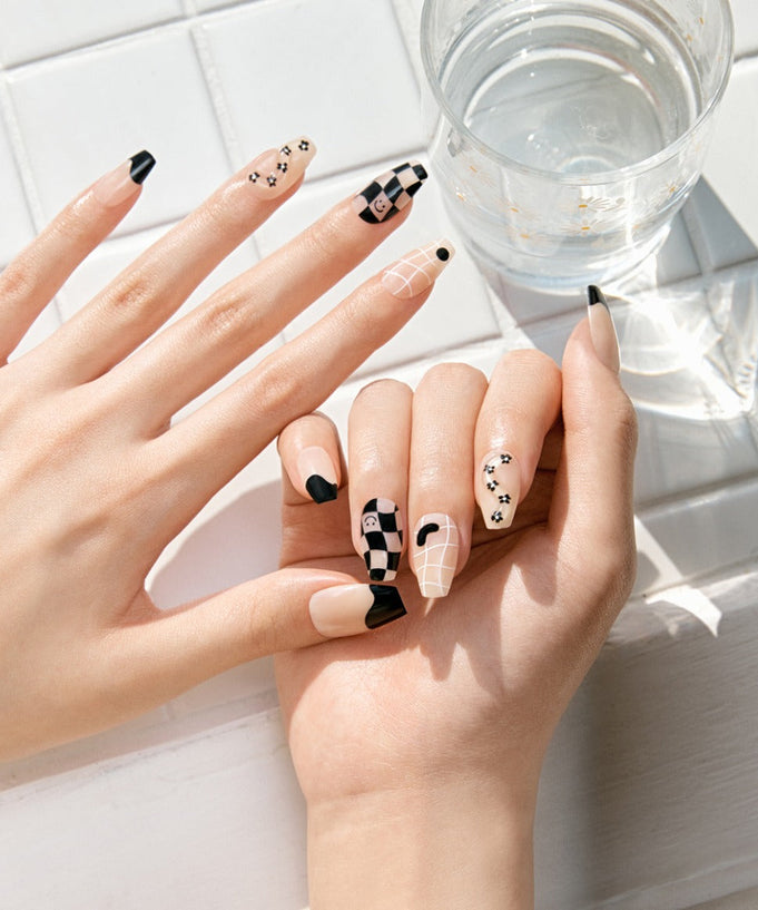 Elegant manicure using DASHING DIVA MAGIC PRESS Nice Way - Coffin nails featuring black and white designs on a tiled surface.
