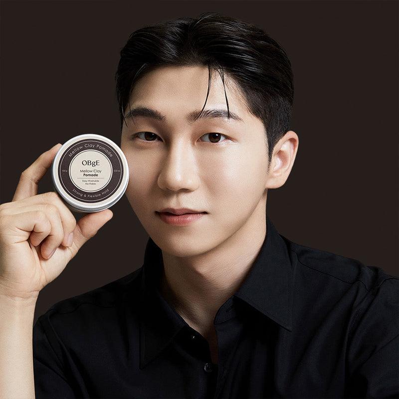 OBGE Mellow Clay Pomade 100g held by a Korean gentleman model in black shirt for Gentleman Korea, premium men’s styling clay pomade