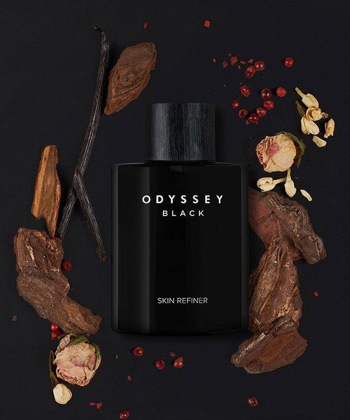 ODYSSEY Black Skin Refiner 130ml bottle surrounded by natural ingredients on black background