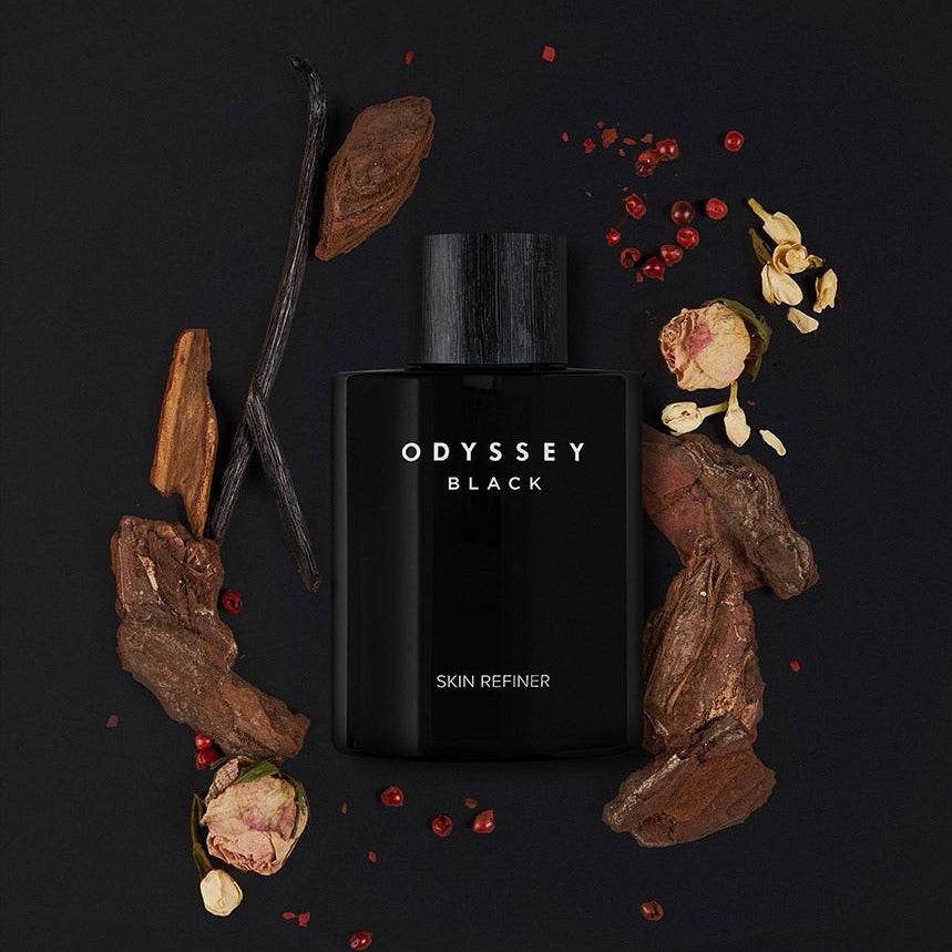 ODYSSEY Black Skin Refiner 130ml bottle surrounded by natural ingredients on black background