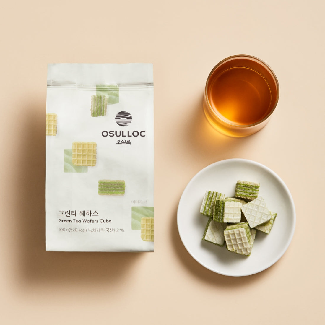 OSULLOC Green Tea Wafers 100g package with a cup of tea and a plate of wafers