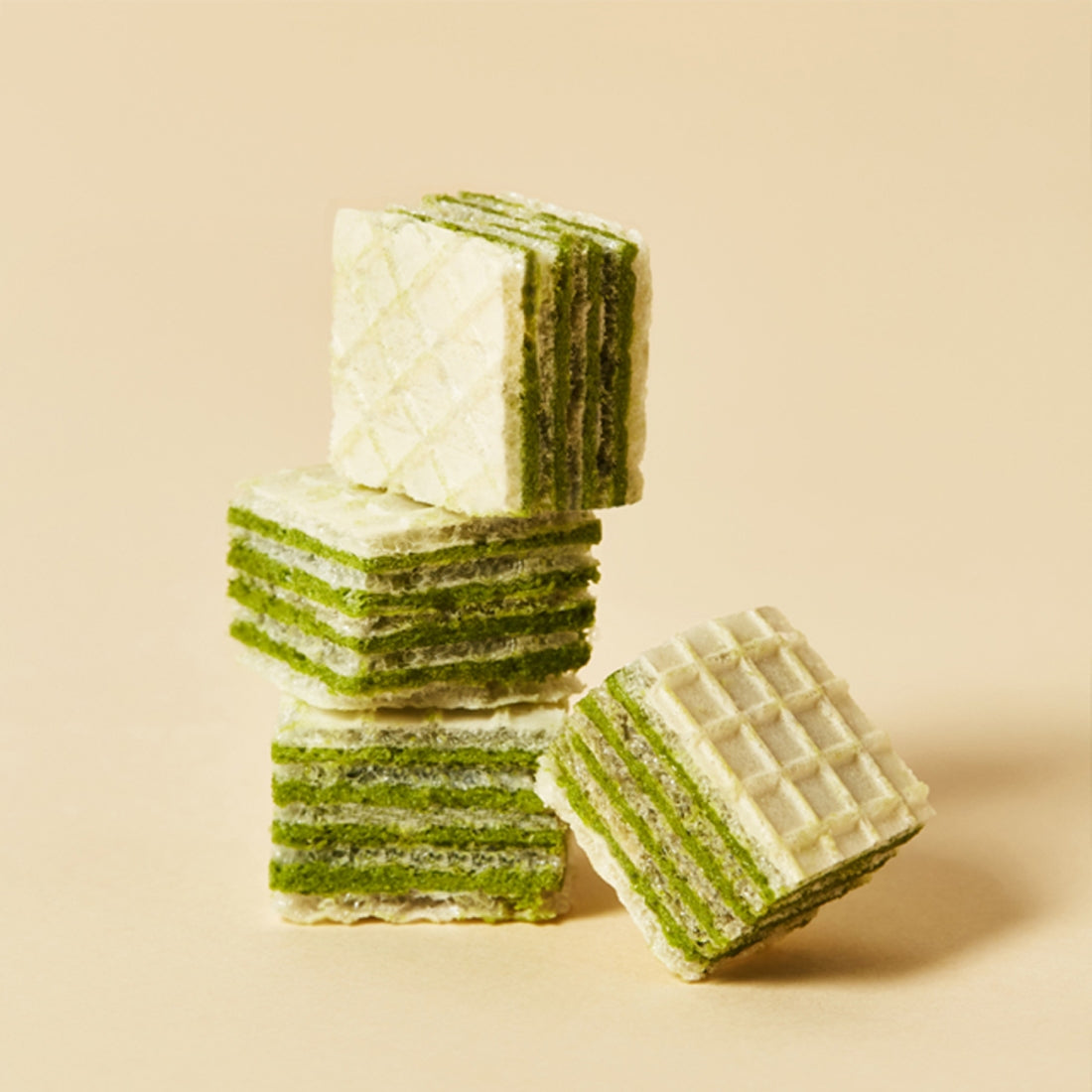 Stack of OSULLOC Green Tea Wafers 100g on a beige background