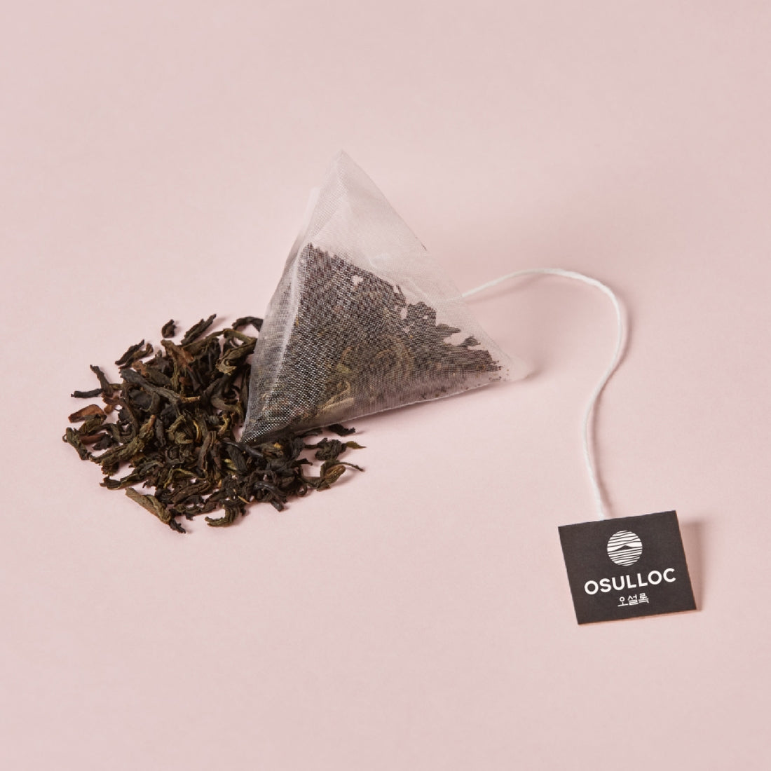 OSULLOC Milky Oolong Tea 10 p. teabag with loose leaves on a pink background.