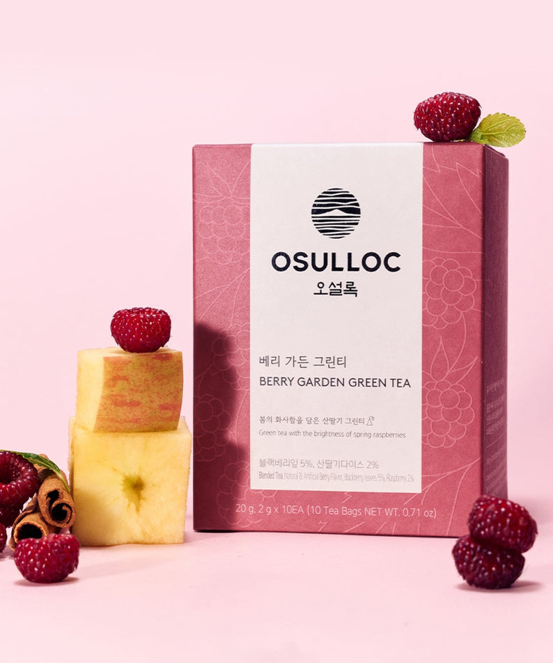 Box of OSULLOC Berry Garden Green Tea 10 P with raspberries and apple slices on a pink background.