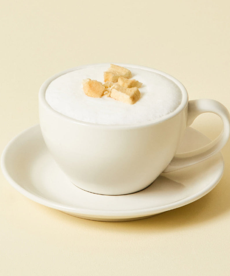 Cup of OSULLOC Chamomile Blend 10 p. tea with frothy top, served in a white cup on a saucer.