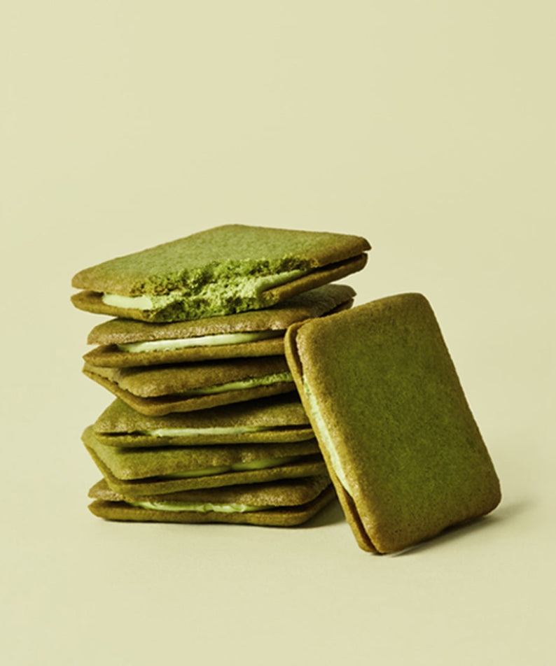 Stack of OSULLOC Green Tea Langue de chat 10 p biscuits with matcha filling on a light background.