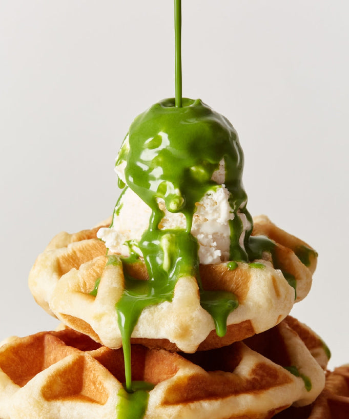 Stack of waffles topped with ice cream and OSULLOC Green Tea Milk Spread 200g drizzling down for a delicious treat.