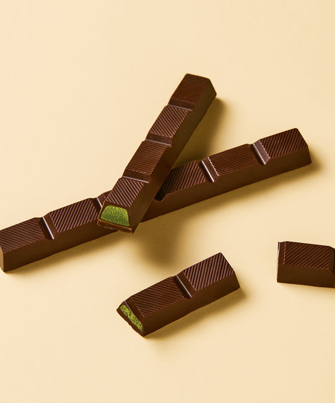 OSULLOC Jeju Island Green Tea Chocolate Bar 120g on beige background, showing green tea filling and rich chocolate texture.