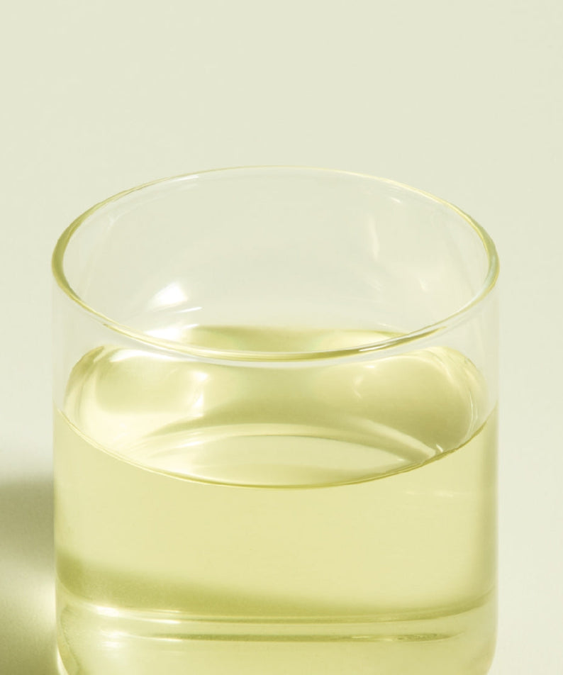 Glass of brewed OSULLOC Jeju Pure Green Tea 20 P with light green color