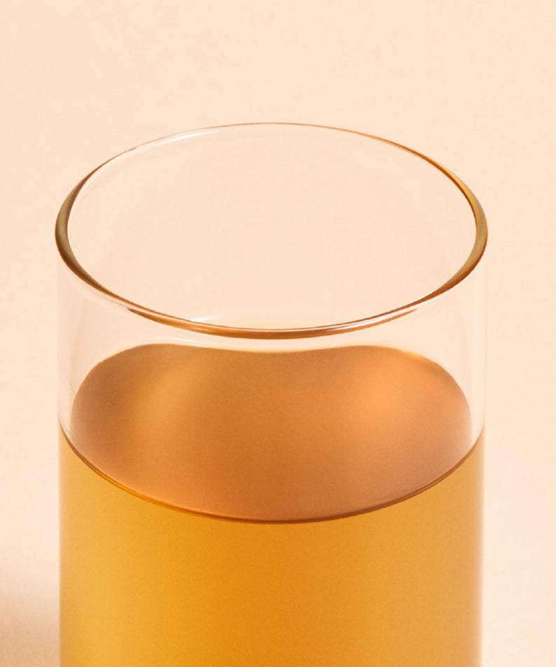Glass of OSULLOC Jeju Volcanic Oolong Tea 20 P with a warm amber color, showcasing premium tea quality.