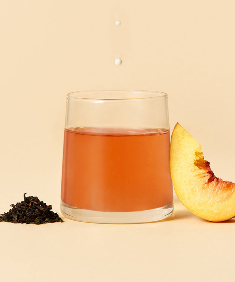 OSULLOC Milky Oolong Tea 10 p with brewed tea, tea leaves, and peach slice on display.