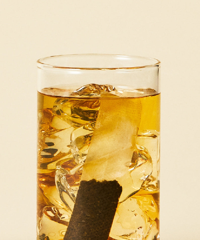 Glass of OSULLOC Moonlight Honey Pear Cold Brew Tea 20 P with ice cubes floating, highlighting refreshing summer beverage.