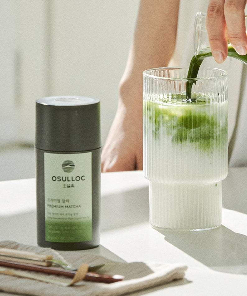 OSULLOC Premium Matcha 40g next to glass of matcha drink on a table