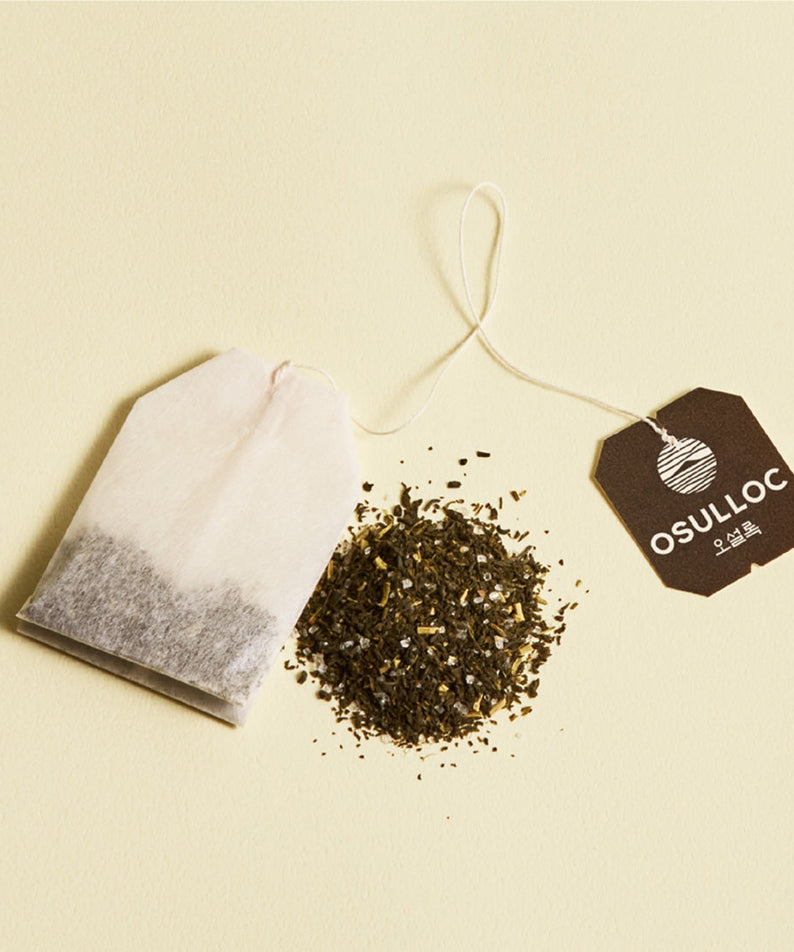 OSULLOC Canola & Apricot Tea 20 P in teabag form with loose tea on a beige background.