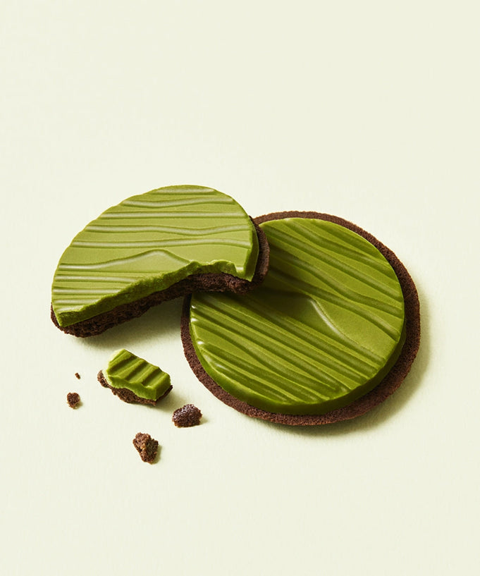Two OSULLOC Signature Biscuits 10 P featuring green tea infused chocolate, with one cookie partially broken, on a light background.