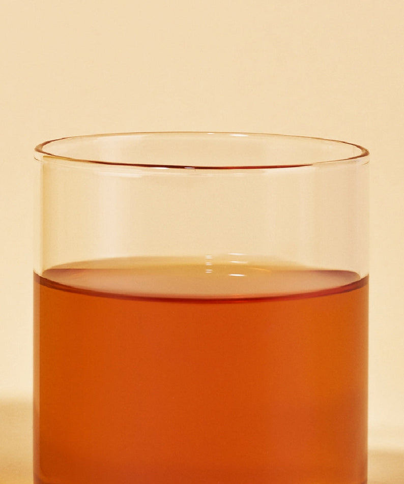 Glass of OSULLOC Vanilla Honey Black Tea 20 P showcasing its rich amber color against a neutral background