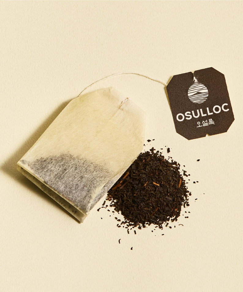 OSULLOC Yuja Earl Grey 20 p tea bag with loose tea leaves on a light background.
