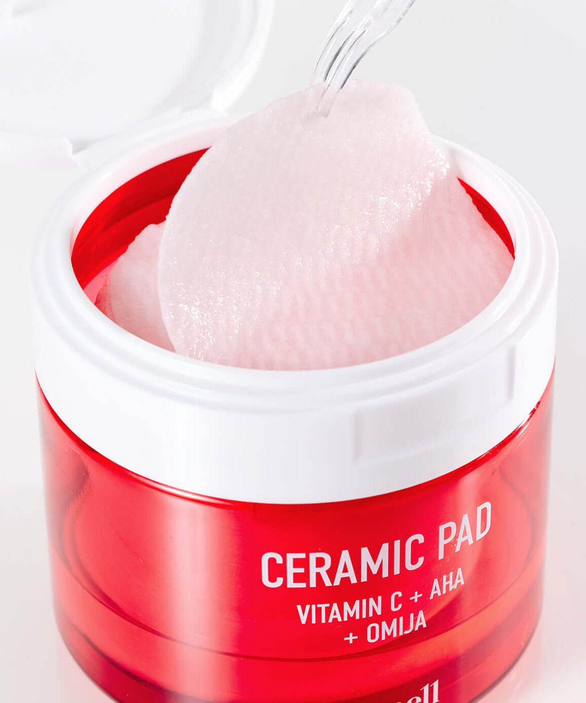 PARNELL AHA Omija Ceramic Pad 60 Pads showing pink textured skincare pads in an open red container with spatula