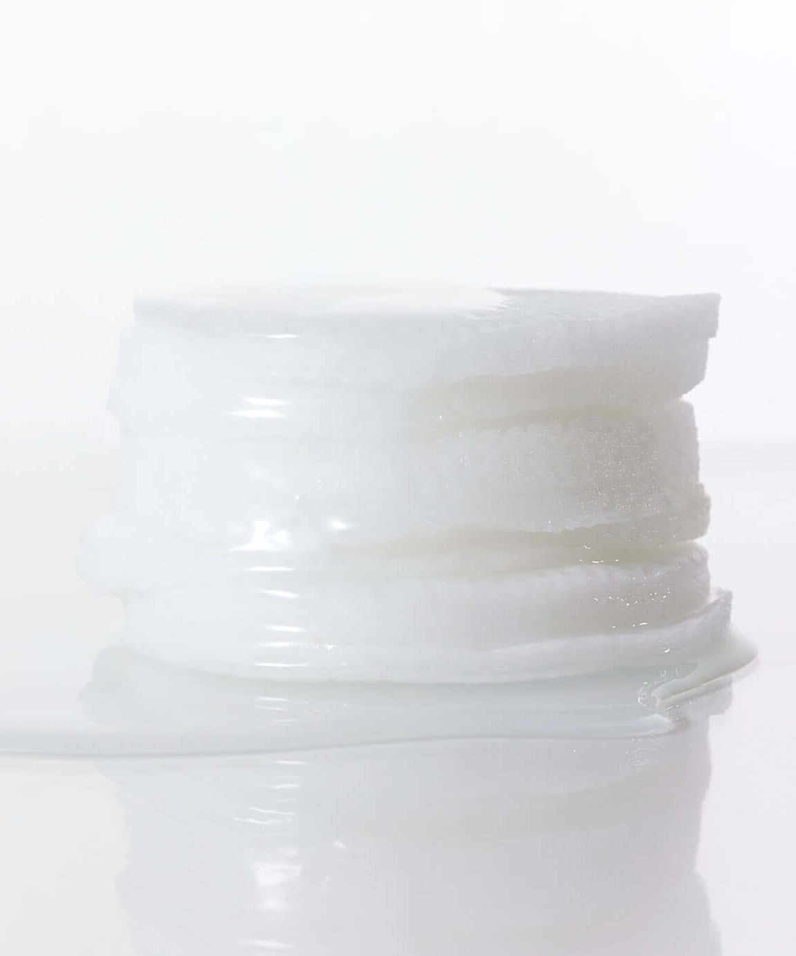 Stack of skincare pads from PARNELL Niacinamide Rice Brightening 60 pads product line on a reflective surface.