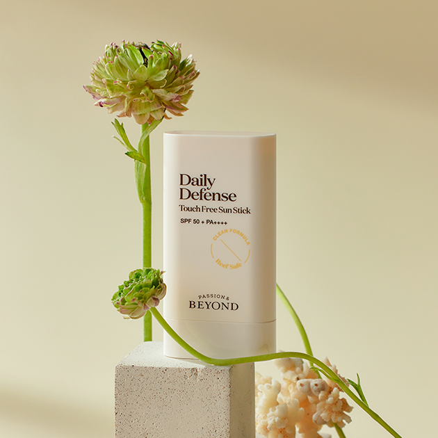 PASSION & BEYOND Daily Defense Touch Free Sun Stick SPF50+ 18g with flowers in the background