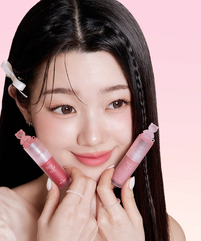 Young woman holding PASSION CAT Bere Blur Tint against a pink background, showcasing vibrant lip color options