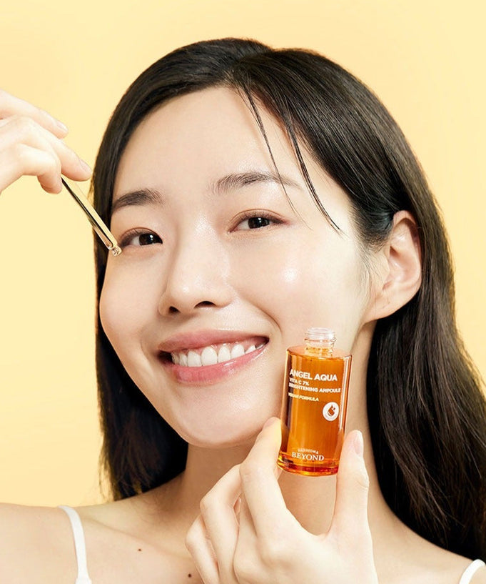 Woman applying PASSION&BEYOND Angel Aqua Vita C 7% Blemmish Ampoule 30ml to face with dropper.