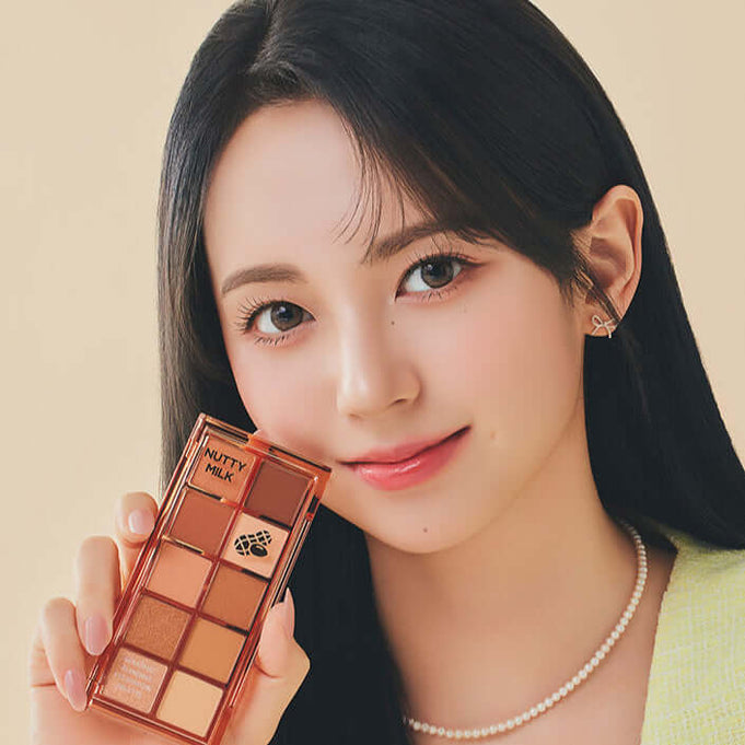 Woman holding PEACH C Seasonal Blending Eyeshadow Palette (Sweet Topping) with a neutral background.