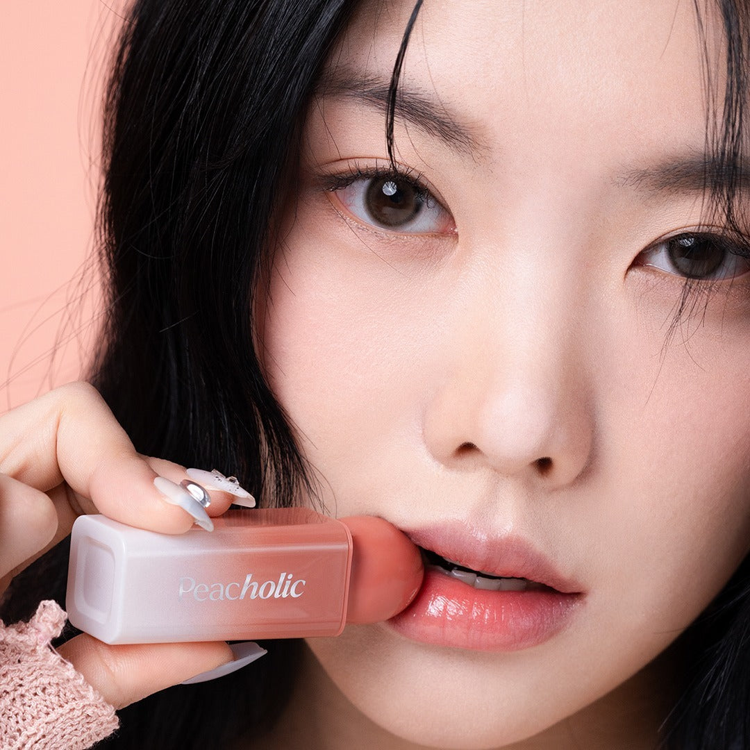 Woman applying PEACHOLIC Water Glow Lip Tint for glossy lips