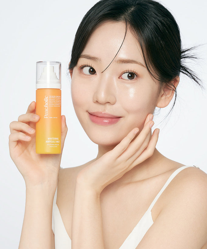 Woman holding PEACHOLIC Whitening Ampoule Mist 100ml, showcasing skincare product.