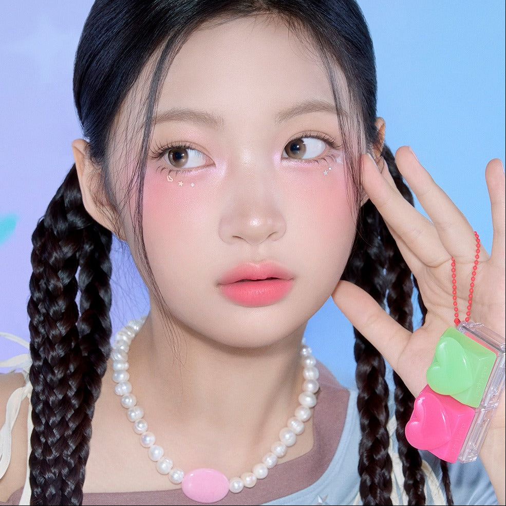 Model wearing PERIPERA Talk Blush Keycap, showcasing vibrant blush tones on cheeks and stylish braided hairstyle with pearl necklace.