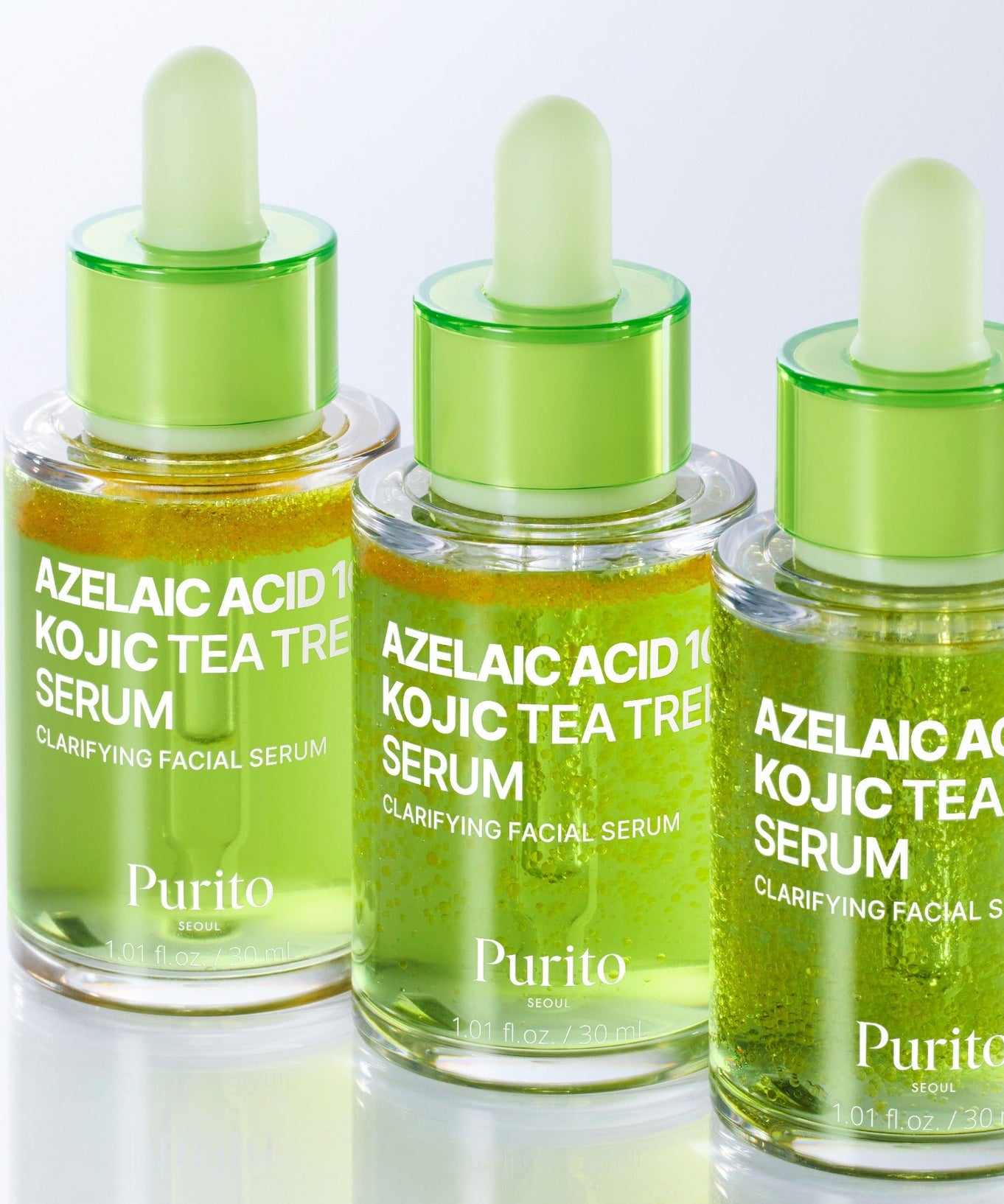 Three bottles of PURITO Azelaic Acid 10 Kojic Tea Tree Serum 30ml for skin clarifying, featuring green dropper caps and clear glass bottles.