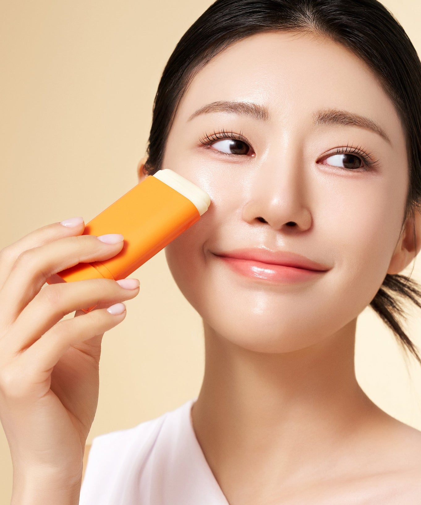 Woman applying PURITO Daily Soft Touch Sun Stick SPF50+PA++++ on face, showcasing skincare product in use.