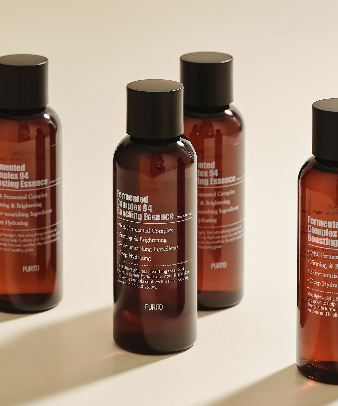 Four bottles of PURITO Fermentedd Complex 94 Boosting Essence 150ml displayed on a neutral background.