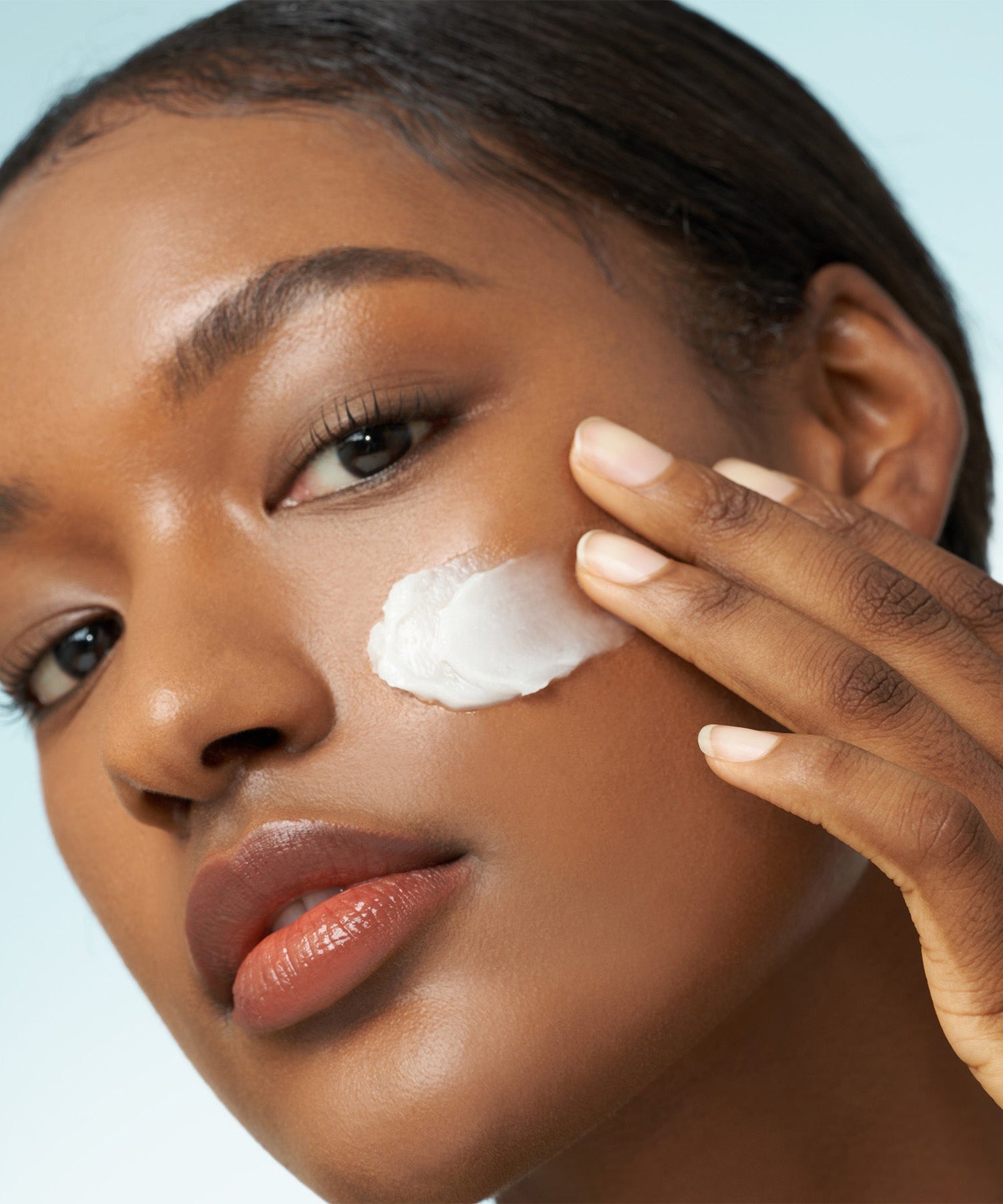 Woman applying PURITO From Green Avocado Cleansing Balm 100ml to her face for skincare.