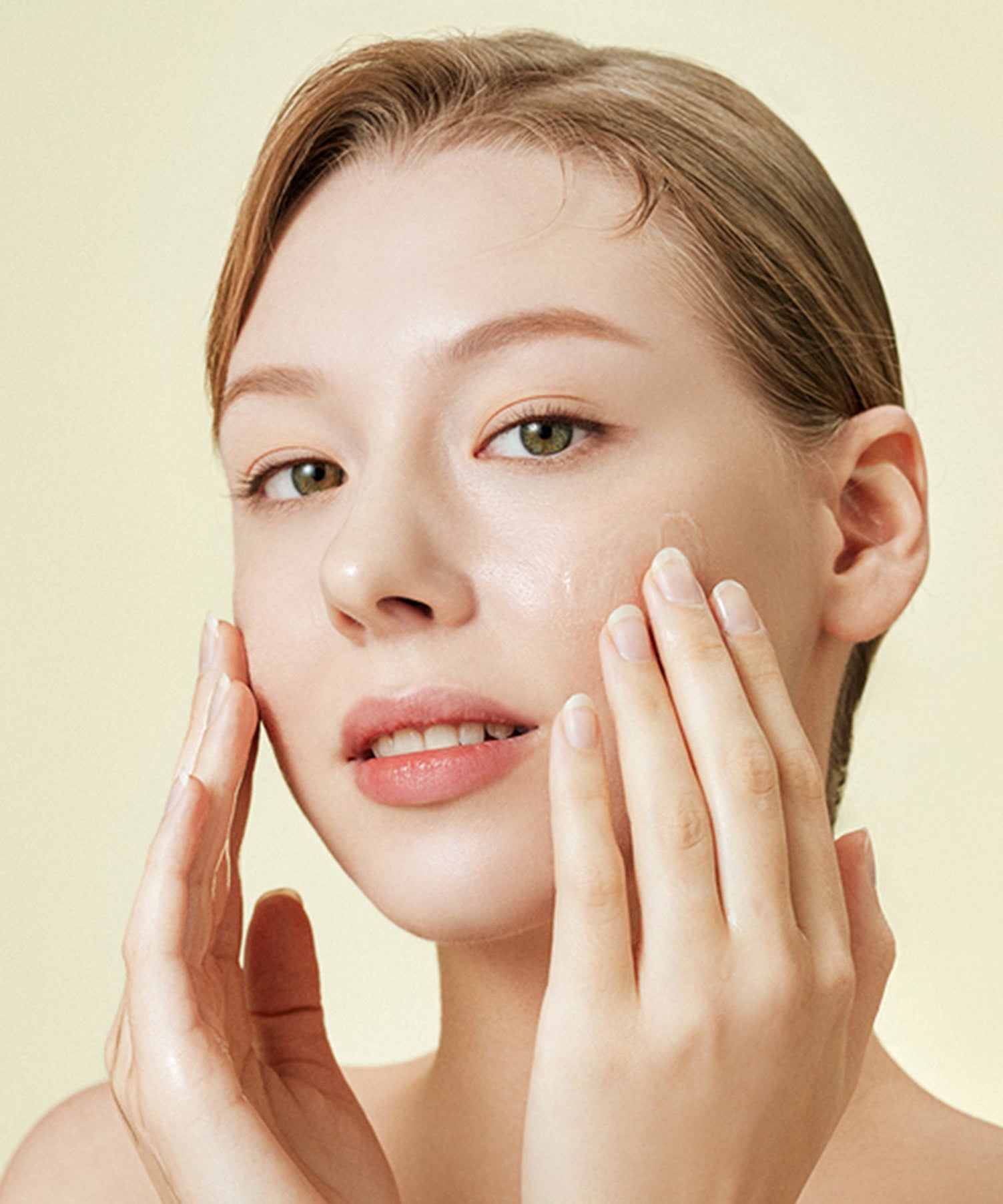 Woman applying skincare product on face, highlighting the benefits of healthy skin care routine and moisturizing techniques.