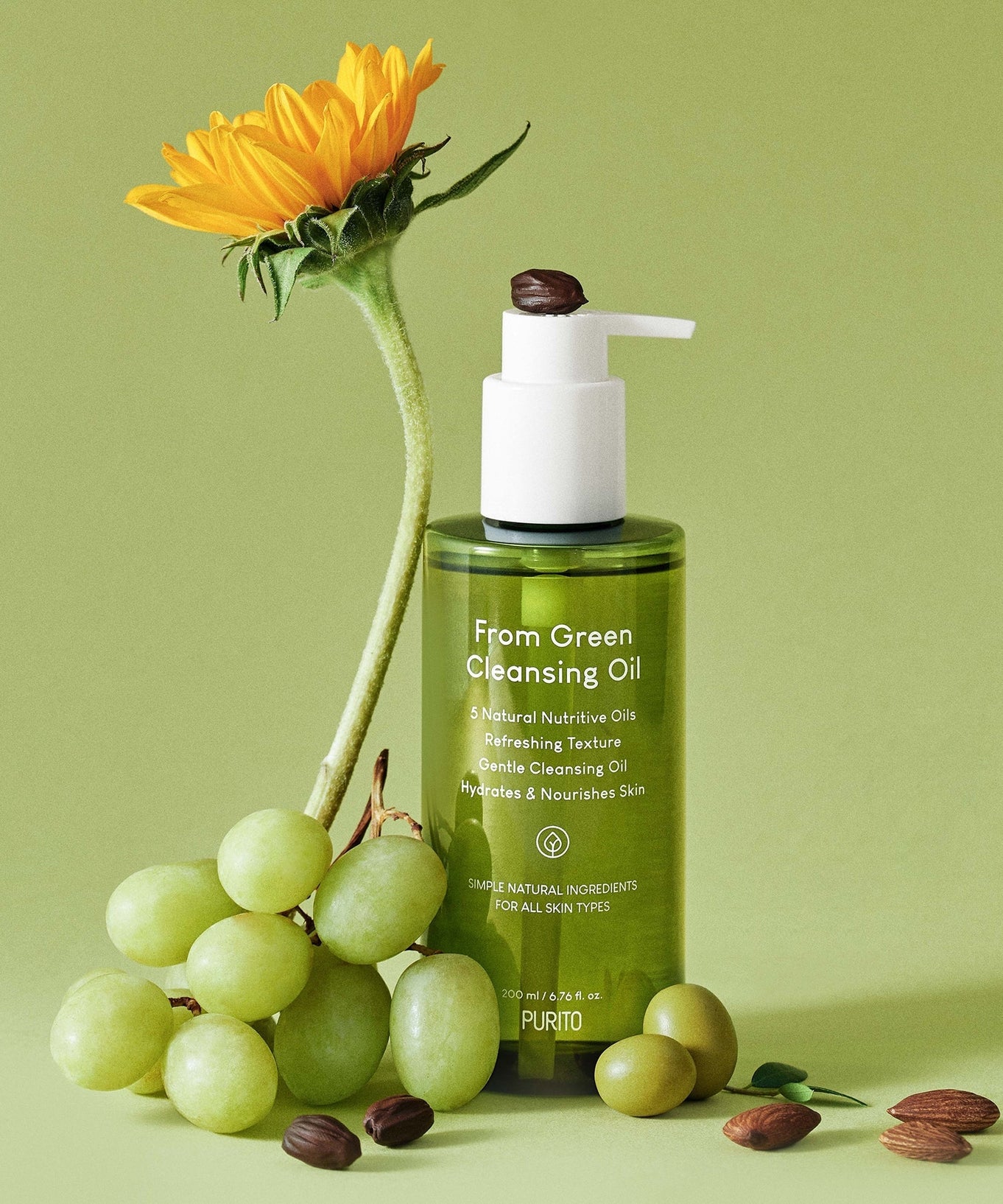 PURITO From Green Cleansing Oil 200ml bottle with flower, grapes, and nuts on green background