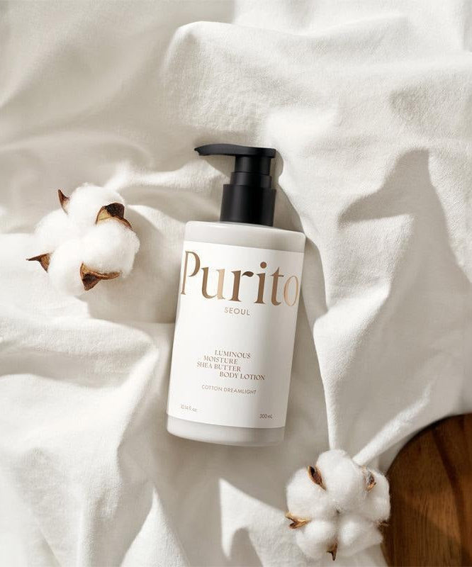 PURITO Luminous Moisture Shea Butter Body Lotion 300ml bottle with cotton flowers on white cloth